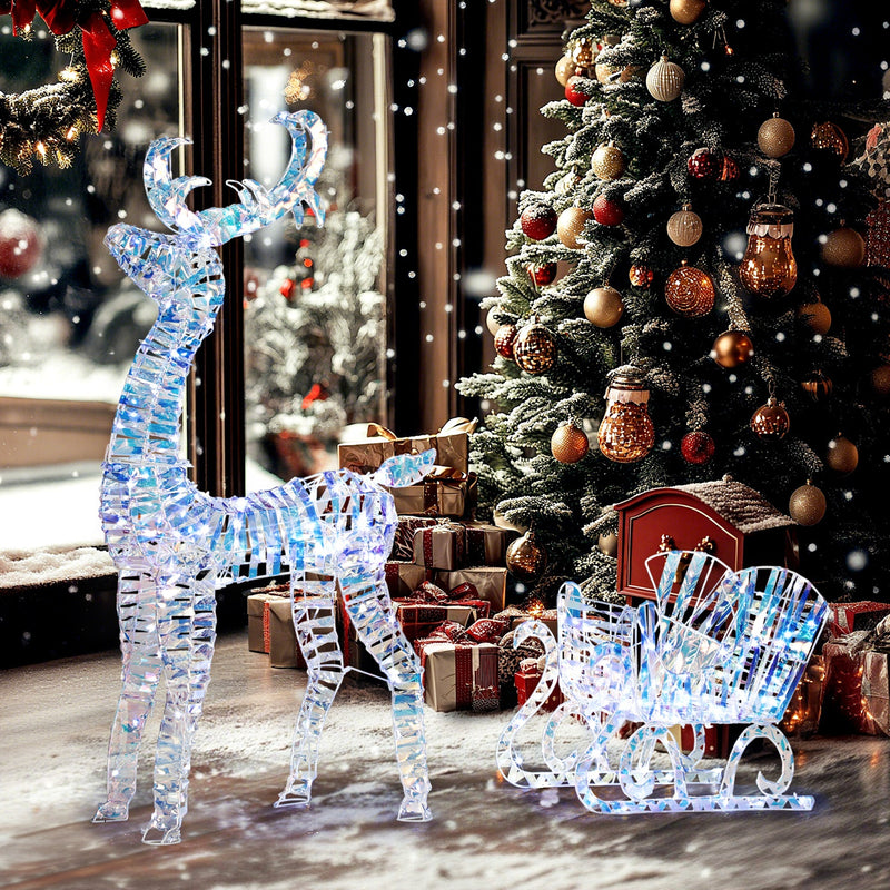 Lit Christmas reindeer and sleigh in front of a decorated Christmas tree and gifts