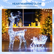 Lit reindeer and sleigh in front of a brick wall with candles and fairy lights