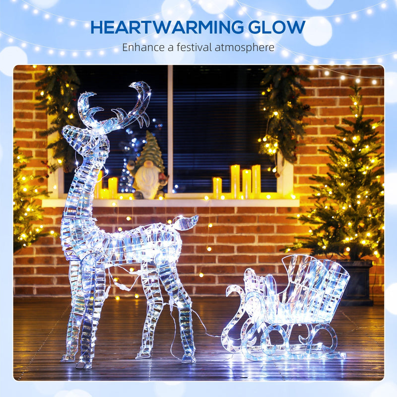 Lit reindeer and sleigh in front of a brick wall with candles and fairy lights