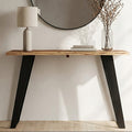 Live edge acacia wood console table with angular black iron legs styled in a hallway