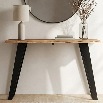 Live edge acacia wood console table with angular black iron legs styled in a hallway