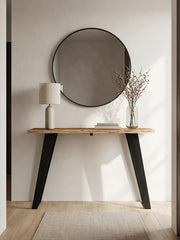 Acacia console table in a living room setting placed behind a sofa with a lamp on top