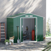 Green 7x4ft metal shed in a garden with a wheelbarrow and tools inside
