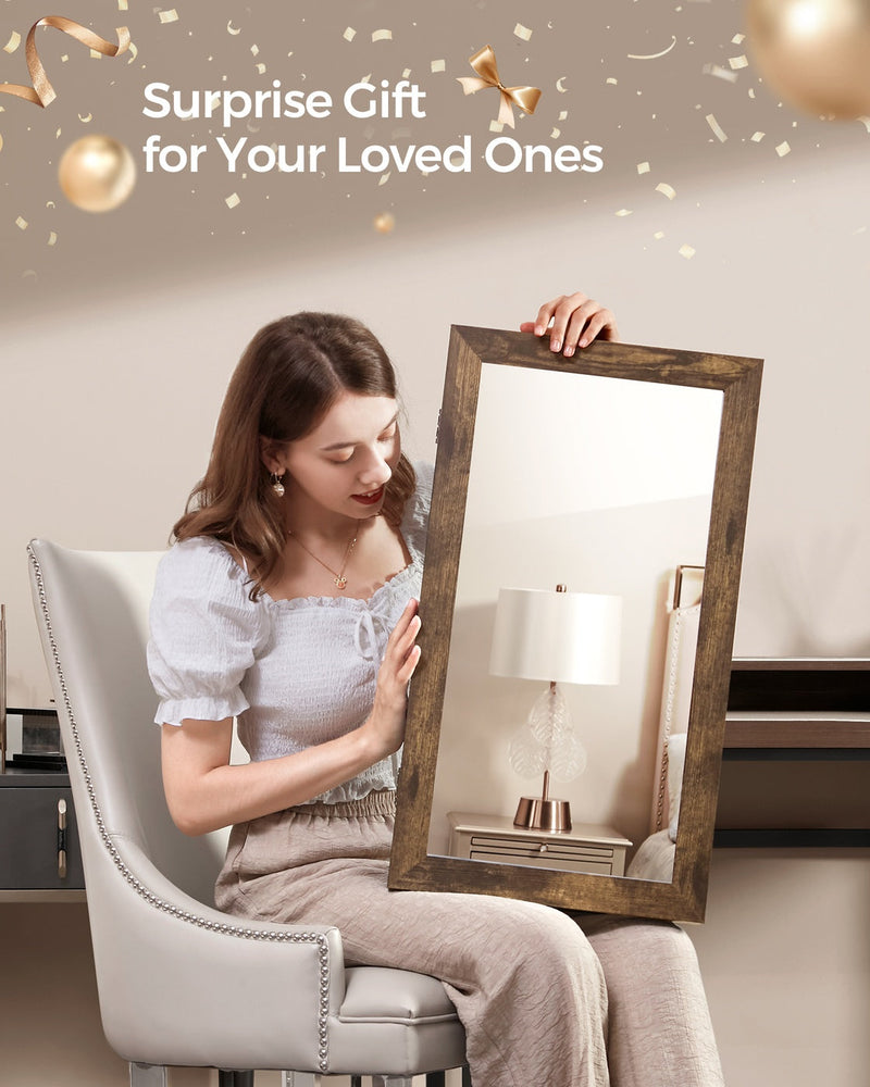 Woman seated in a cream chair holding the rustic brown mirrored jewellery cabinet as a gift