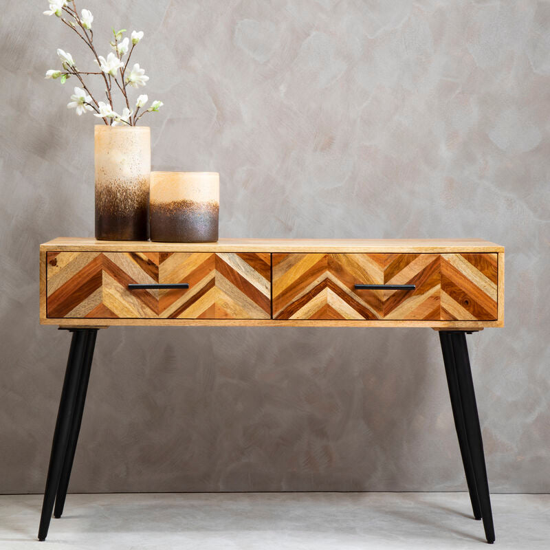 Natural mango wood console table with two drawers and black iron legs in a styled hallway