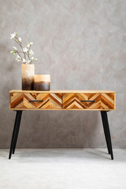 Mango wood console table styled beneath a mirror in an entry hall