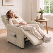 Woman relaxing fully reclined in the beige recliner armchair by a window