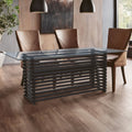 Clear glass dining table with slatted matt black base set for six in a modern dining room