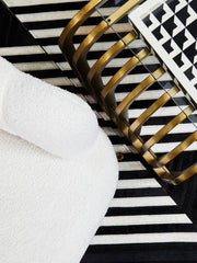 Matte gold end table styled in a contemporary lounge with velvet seating