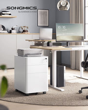 White filing cabinet under a standing desk with a printer on top in a home office