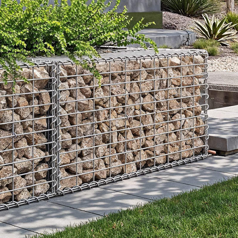Stone-filled gabion wall edging a raised garden border beside a lawn