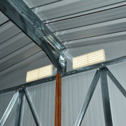 Inside the metal shed roof, showing the galvanised steel apex trusses and two louvre vents set into the gable