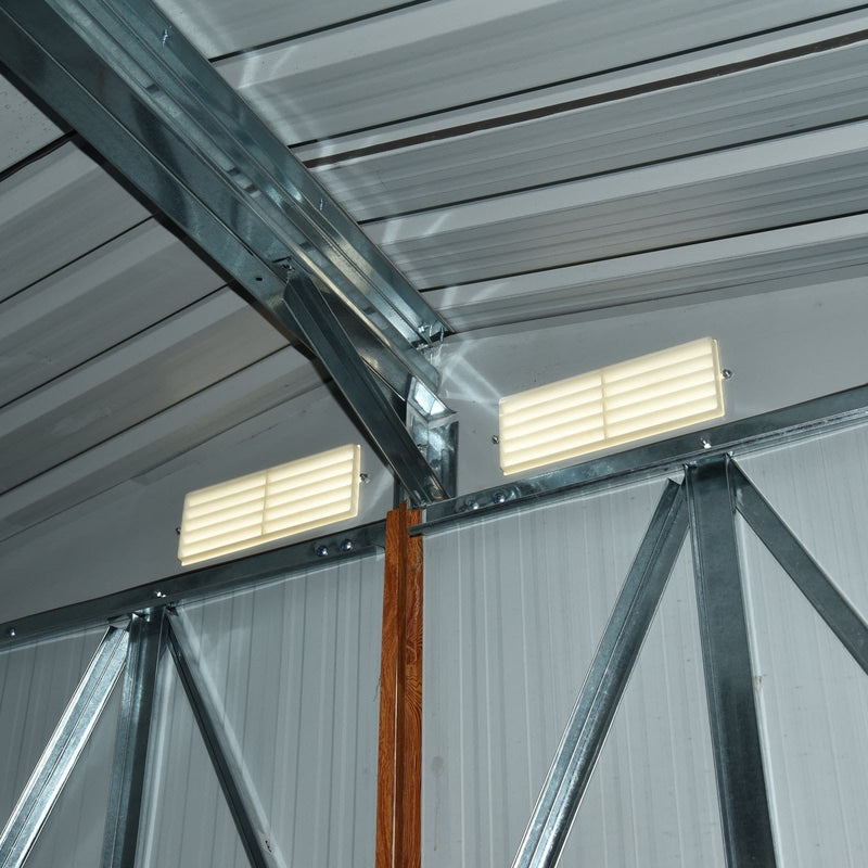 Inside the metal shed roof, showing the galvanised steel apex trusses and two louvre vents set into the gable