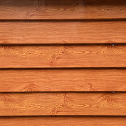 Close-up of the overlapping brown wood grain finish printed onto the shed's steel cladding boards