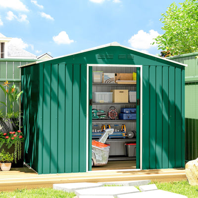 Green metal shed on garden decking with sliding doors open showing shelves of storage boxes