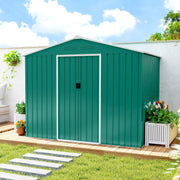 Green 8x6ft metal shed with doors closed on decking, flower planters on either side