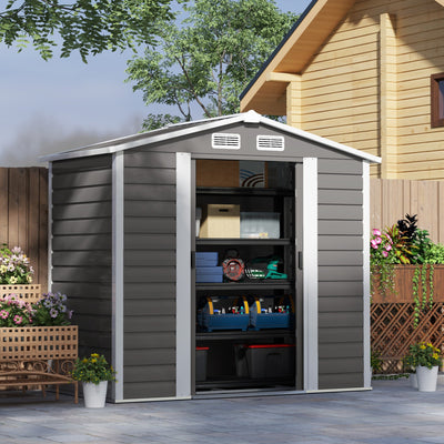 Light grey 7x4ft metal shed in a garden with both sliding doors open, revealing stored boxes and equipment