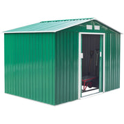 Green shed viewed from the side with the door open and a spade standing inside