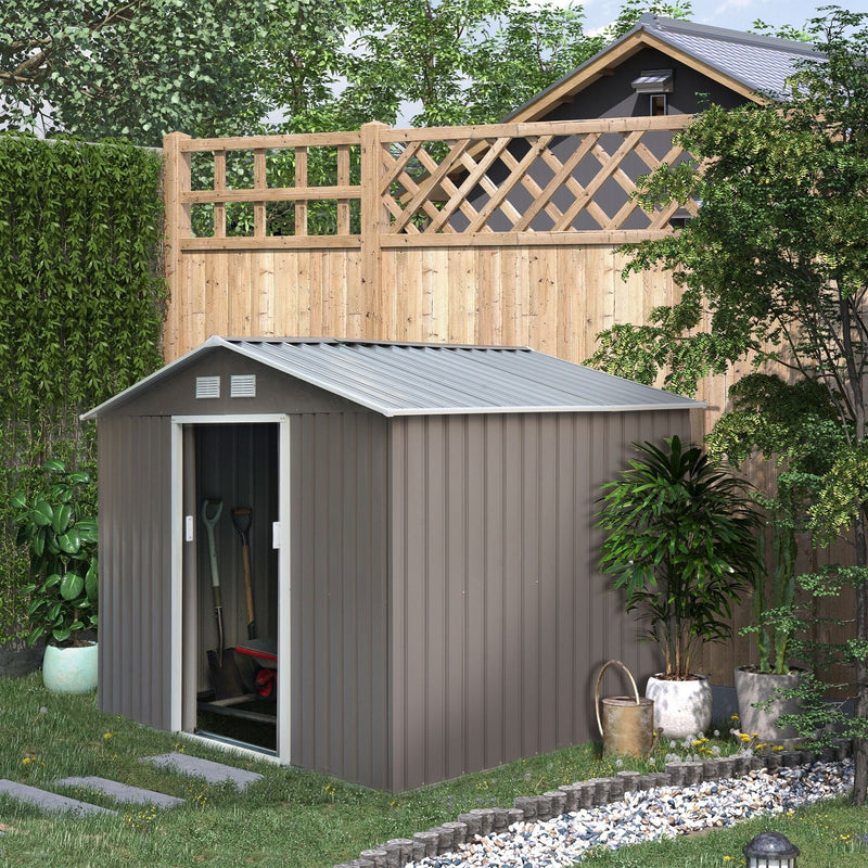 Grey metal garden shed in a planted garden with the sliding door open and tools inside