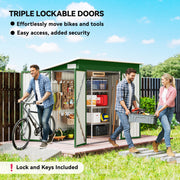 Couple moving a bike and a toolbox beside the green shed with all three doors open