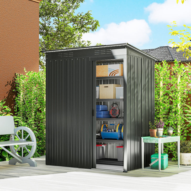 Dark grey metal shed on a patio with the sliding door open showing stored tools