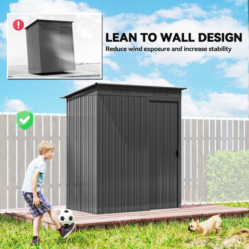 Dark grey metal shed set against a garden fence while a child plays football