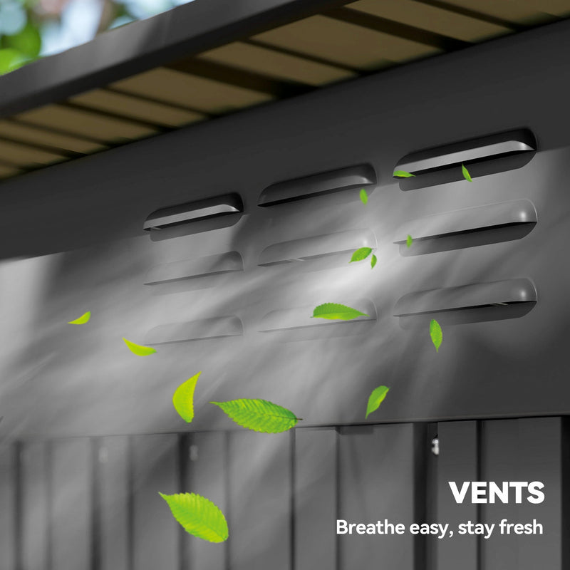 Close-up of the roof vent slots on the dark grey shed with leaves blowing past