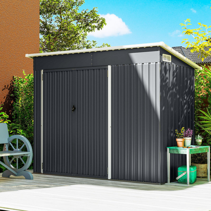 Dark grey pent roof metal shed closed, standing against a house wall in a garden