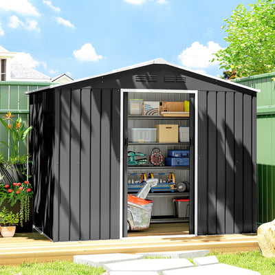 Dark grey metal shed on garden decking with sliding doors open showing shelves of storage boxes