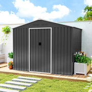 Dark grey 8x6ft metal shed with doors closed on decking, flower planters on either side