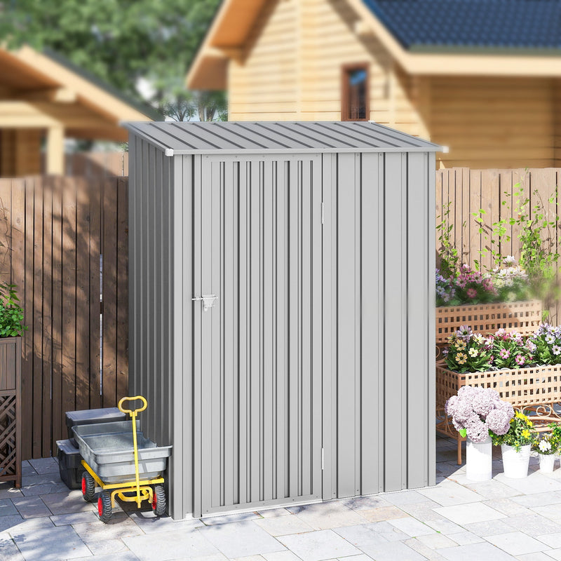 Pent roof metal shed beside a dark wooden fence with a garden trolley alongside