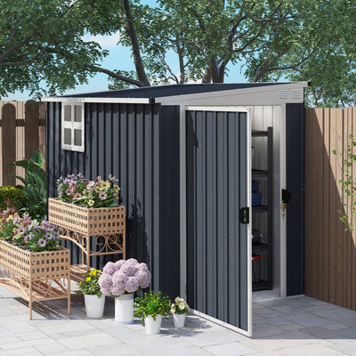 Dark grey shed on a patio with the end door open and flower planters in front