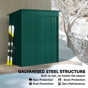Green metal garden shed standing in snow with skis leaning against the side