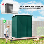 Green metal shed placed against a garden fence while a child plays football