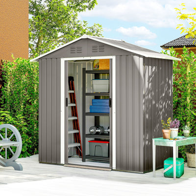 Light grey metal shed on a patio with sliding doors open, step ladder and storage boxes inside