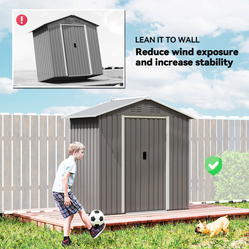 The shed sited against a garden fence to reduce wind exposure and improve stability