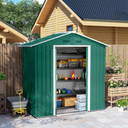 Green metal shed beside a log cabin with the sliding doors open and tools stored inside
