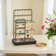 Lifestyle photo of the black metal jewellery organiser holding gold necklaces, bracelets and watches on a dressing table