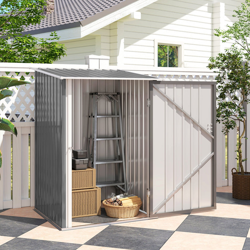 Grey lean-to shed beside a white house with its door open and wicker baskets inside