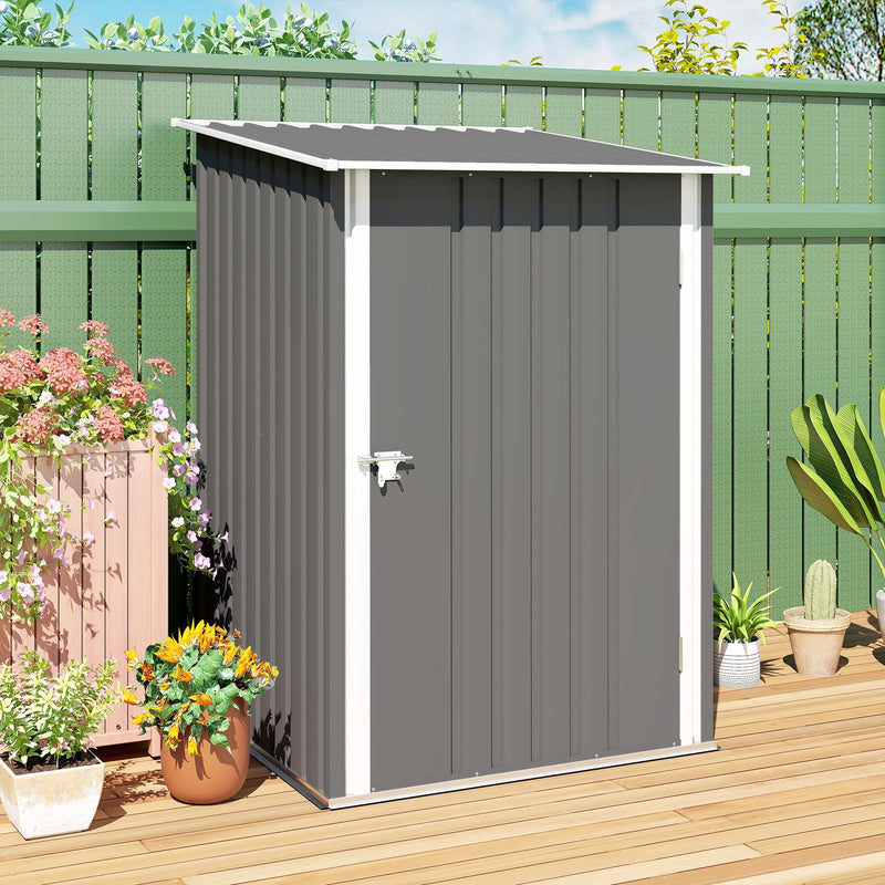 Closed grey lean-to shed on decking against a green fence with potted plants