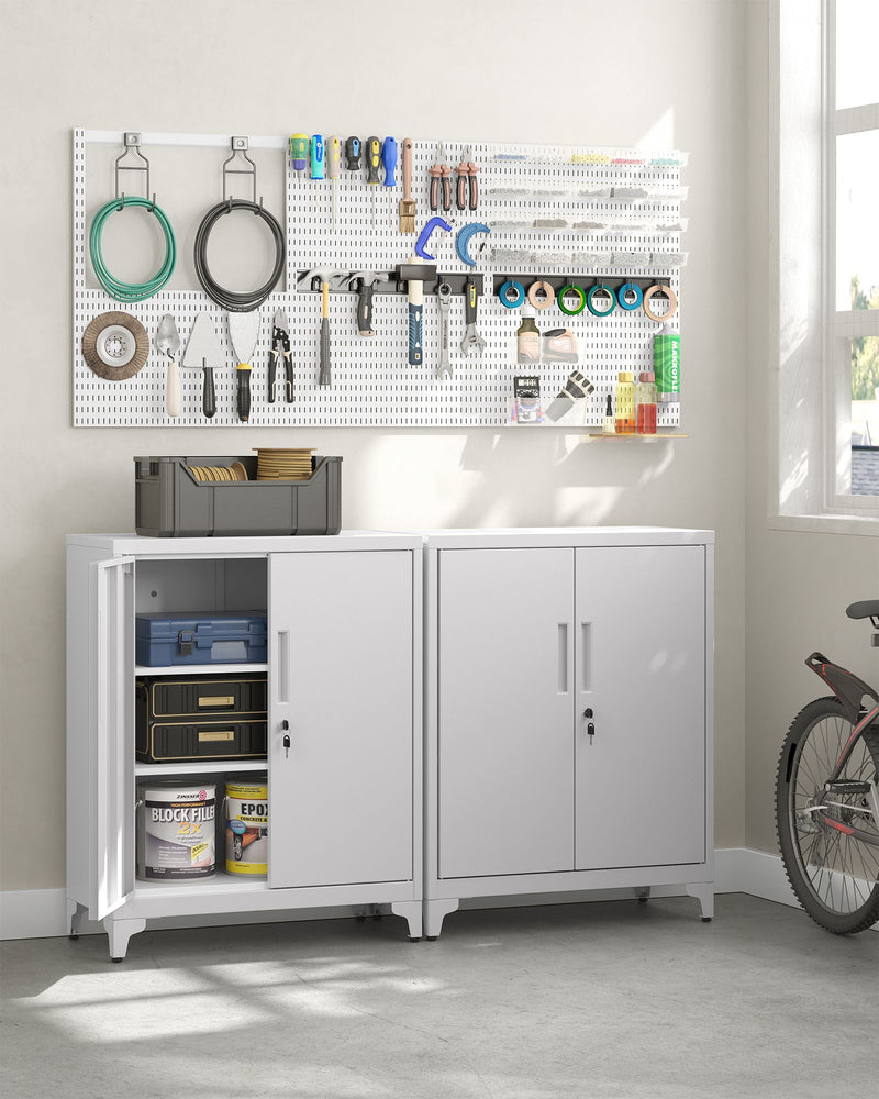 Lifestyle photo of two white cabinets in a garage storing tools, paint tins and supplies