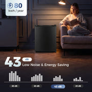 Black mini fridge in a dim living room with 43 dB and 80 kWh a year labels