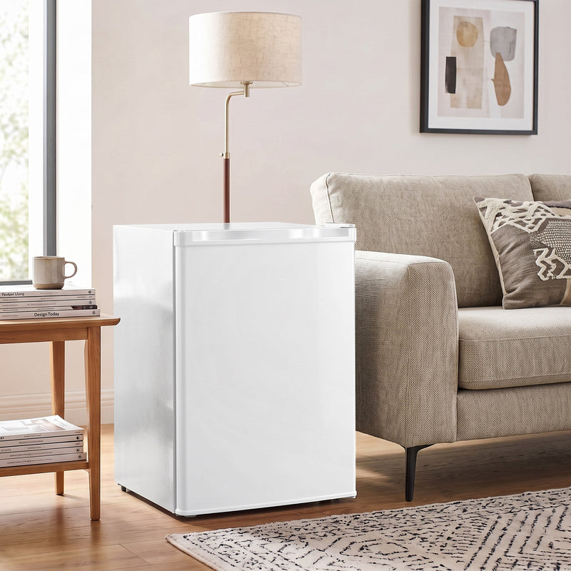 White mini fridge next to a sofa and side table in a living room