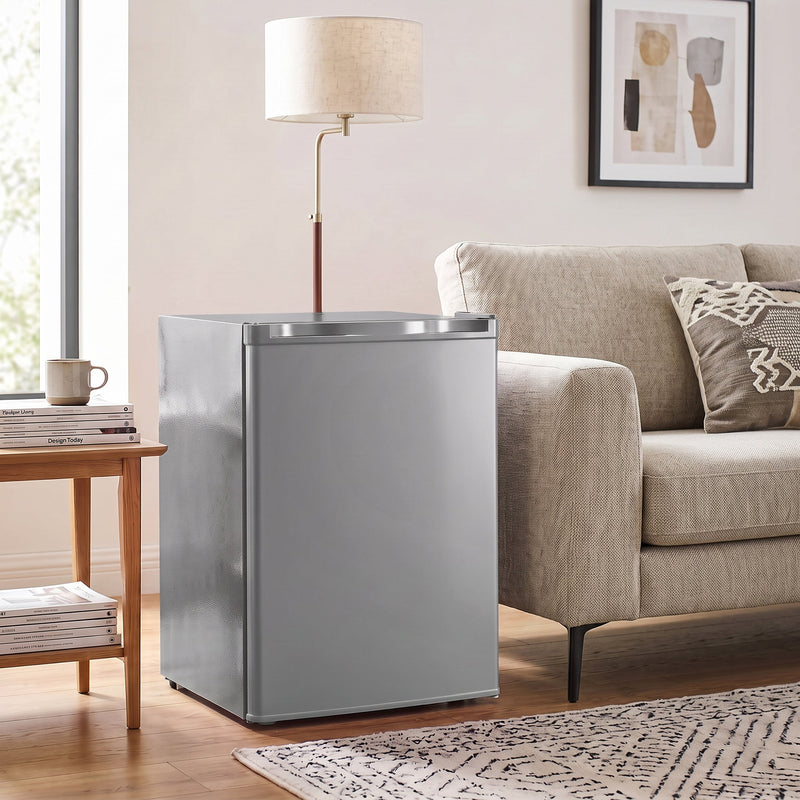 Grey mini fridge next to a sofa and side table in a living room