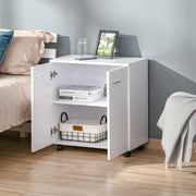 White sideboard used by a bed with one door open showing a shelf and a wire basket