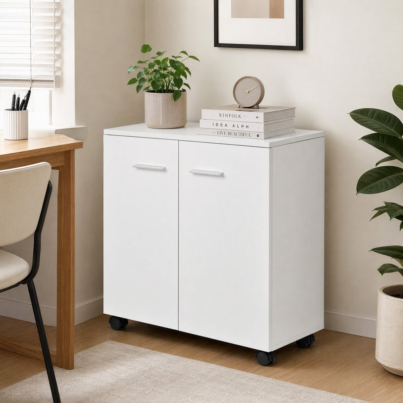 White sideboard beside a desk with a plant, clock and books on top