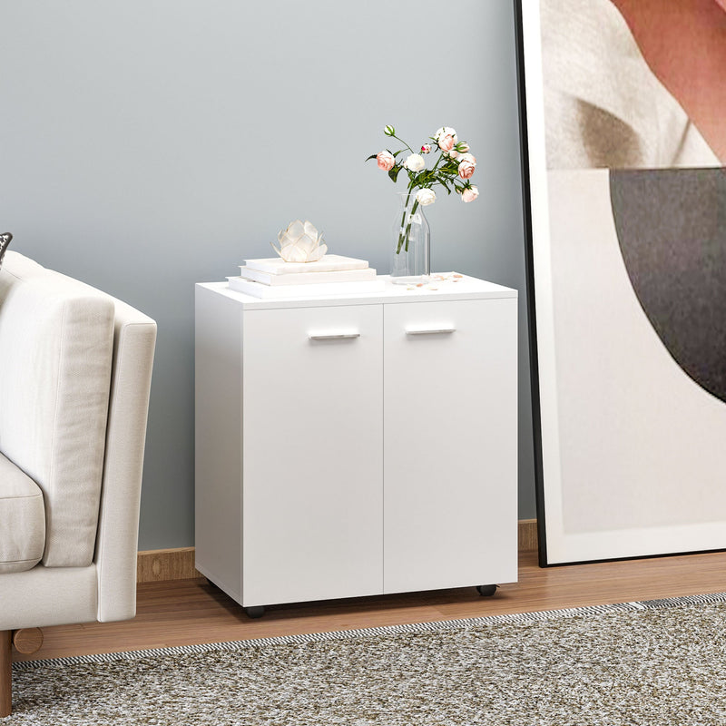 White sideboard in a living room with flowers and ornaments on top