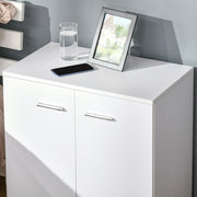 White sideboard top with a phone, glass and photo frame next to a bed
