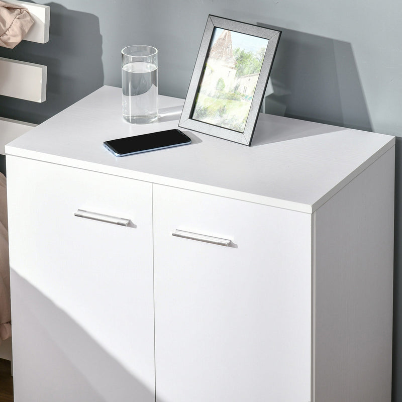 White sideboard top with a phone, glass and photo frame next to a bed