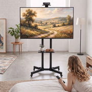 Lifestyle photo of the mobile TV stand in a bedroom with a webcam mounted above the screen